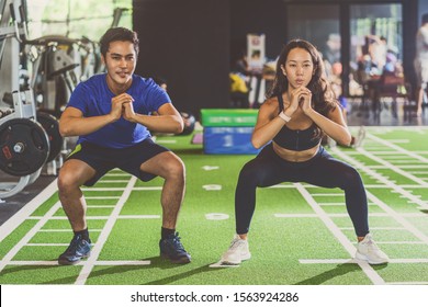 Couple young diversity working out in gym fitness sport complex, doing squad and cardio, posture position, Push up on weights, sports and healthcare,asian and asean people, concept - Shutterstock ID 1563924286