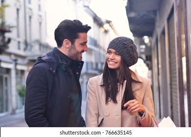 A couple of young engaged or friends, while they are shopping, having fun together. Concept of: shopping, entertainment, friendship, love and leisure.