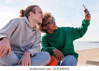 Couple Of Young Friends Smiling While Taking A Selfie Photo With The Mobile Phone, Concept Of Friendship And Technology