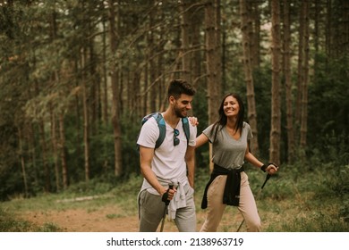Couple of young hikers with backpacks walk through the forest - Shutterstock ID 2138963719