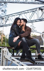 Couple Of Young Man And Woman In Love Having Fun Together At Steel Construction At Romantic Dating, Sensual Relationship And Desire Of Lovers, Candid Lifestyle, Vertical Image With Industrial Style