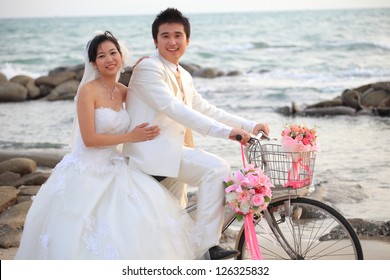 couple of young man and woman in wedding suit riding old bicycle on sand beach - Powered by Shutterstock