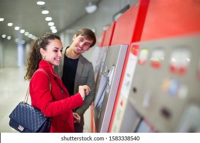 Couple Of Young Passengers Buying Subway Ticket At Station Machine
