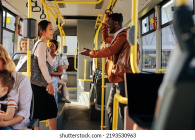 A couple of young passengers are talking while they're riding the city bus - Powered by Shutterstock