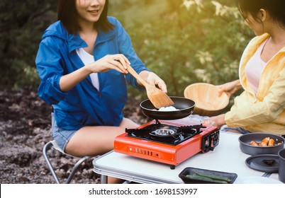 Couple Young Women Friends Cooking Food On Stove For Dinner At Outdoor Together,Enjoying Camping Concept