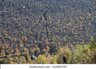 Couple Zip Line A Mountain During Fall Foliage