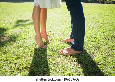 Couples bare feet standing on grass on a sunny day