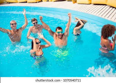 Couples bonding cool lifestyle funky disco moves glasses tourism hotel spa teens concept. Handsome guys attractive sporty ladies standing in swimming pool raising fists celebrating event - Powered by Shutterstock