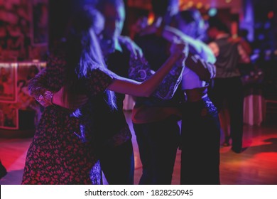 Paare, die traditionelle latin argentinische Tanz Milonga im Ballsaal tanzen, Tango salsa bachata Unterricht in den roten Lichtern, Tanzfestival
