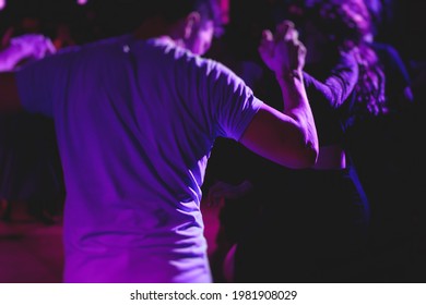 Couples dancing traditional latin argentinian dance milonga in the ballroom, tango salsa bachata kizomba lesson in the red, purple and violet lights, dance festival 