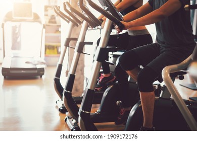 Couples exercise for good health by cycling at the gym.