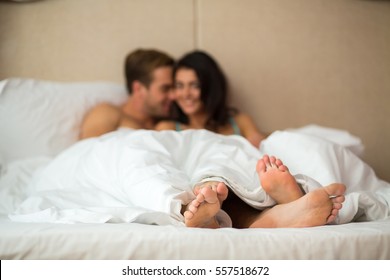 Couple's feet under blanket. Caucasian woman and man indoor. Home comfort and romance. - Powered by Shutterstock