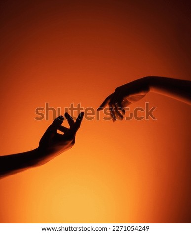 A couples hands almost touching 