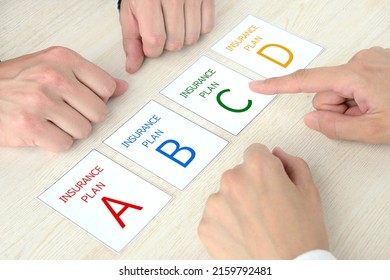 Couple's hands and cards with insurance plan A to B words - Shutterstock ID 2159792481