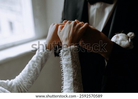 A couple's hands intertwined while exchanging wedding rings, showcasing love and commitment in a refined environment.