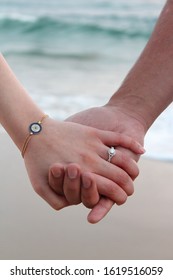 Couples Holding Hands During A Beach Engagement Photo Shoot.