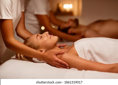 Couples Massage. Girlfriend And Boyfriend Enjoying Relaxing Beauty Treatment Lying In Masseur's Bed At Spa Center, With Eyes Closed. Wellness Procedure, Massaging Therapy. Selective Focus, Low Light