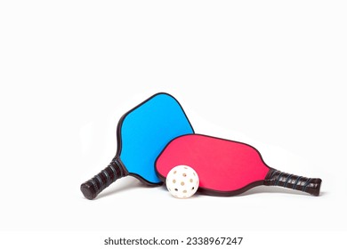 Couples Pickleball....Pink and Blue Pickleball paddles with white Pickleball on a white background.