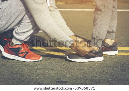 Couples runners Jogging Man tie his shoes to his girlfriend.