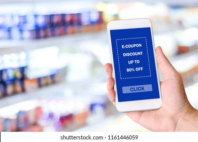 Coupon For Digital Discount, Hand Holding Smartphone With E-coupon On Screen Device At Grocery, Shopping Online Business Promotion, E Commerce, Digital Marketing