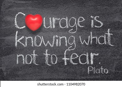 Courage is knowing what not to fear quote of ancient Greek philosopher Plato written on chalkboard with red heart symbol instead of O