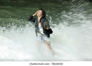 Courageous Asian Woman Getting Dressed Standing In  Rough Breaker At Night, Motion Blurry