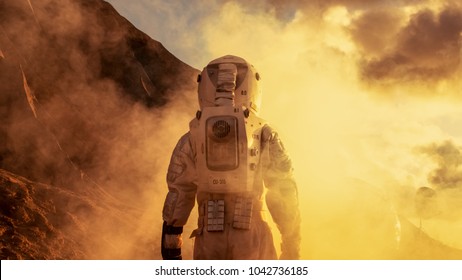 Courageous Astronaut in the Space Suit Explores Red Planet Mars Covered in Mist. Adventure. Space Travel, Habitable World and Colonization Concept.