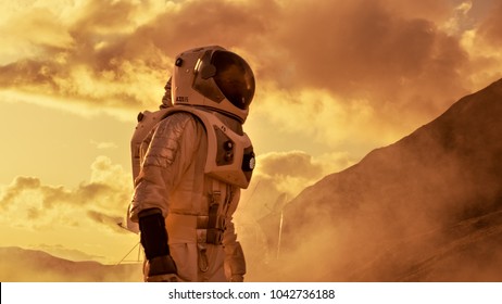 Courageous Astronaut In The Space Suit Explores Red Planet Mars Covered In Mist. Adventure. Space Travel, Habitable World And Colonization Concept.