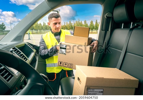 Courier with cardboard boxes. Portrait of courier
at work. Delivery man takes boxes out of car. Courier with boxes in
his hands. Delivery service worker. Postal company employee.
Postman works