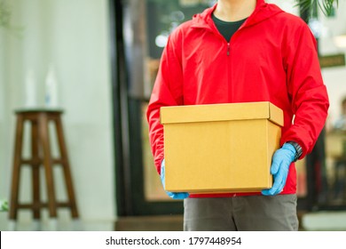 The Courier Carried A Cardboard Box Wearing Rubber Medical Gloves. Fast Package Delivery To Your Doorstep.