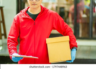 The Courier Carried A Cardboard Box Wearing Rubber Medical Gloves. Fast Package Delivery To Your Doorstep.