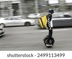 A courier carries an order on an electric unicycle