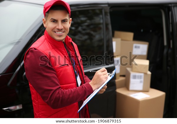 Courier checking amount of parcels in delivery van\
outdoors. Space for\
text