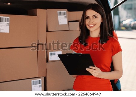 Courier with clipboard near delivery van outdoors