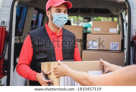 Courier delivering packages with truck while wearing protective face mask for coronavirus prevention - Focus on man worker