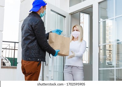 Courier, delivery man in protective mask and medical gloves delivers takeaway food. Delivery service under quarantine, disease outbreak, coronavirus covid-19 pandemic conditions. Stay home