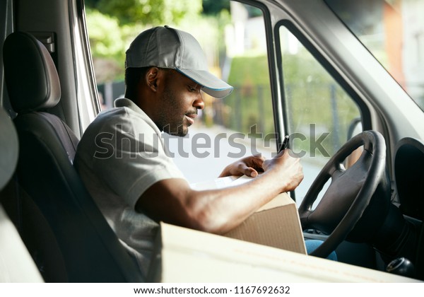 Courier. Delivery Man Reading Addresses Sitting In\
Delivery Van