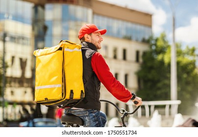 Courier Guy Delivering Food Riding Bike In City, Working In Meal Delivery Company. Free Space For Text