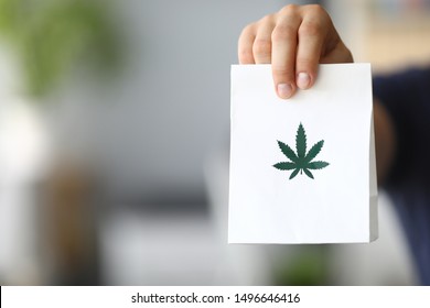 Courier hand passing package with marijuana to client close-up
