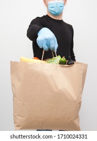 The Courier Is Holding The Paper Bag From Grocery Store In Hand Wearing The Latex Gloves