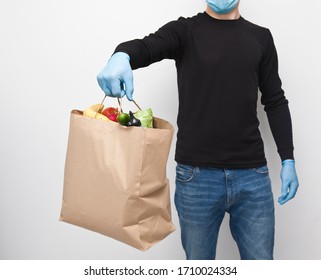 The Courier Is Holding The Paper Bag From Grocery Store In Hand Wearing The Latex Gloves