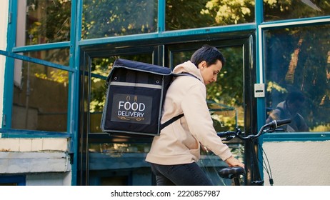 Courier On Bicycle Delivering Food Order Package, Takeaway Lunch Meal In Paperbag For Restaurant Customer. Food Delivery Service Worker Giving Fastfood At Office Building Front Door.