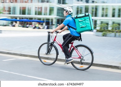Courier On Bicycle Delivering Food In City - Shutterstock ID 674369497