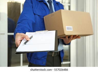 Courier with parcel and clipboard on doorstep, closeup