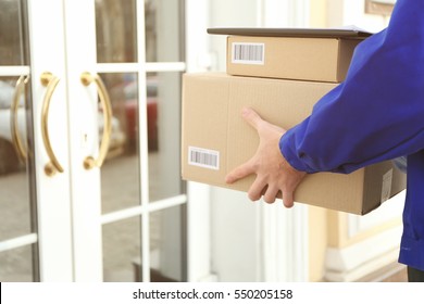 Courier with parcel in doorway, closeup (it's not real QR code)