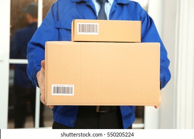 Courier with parcel in doorway, closeup (it's not real QR code)