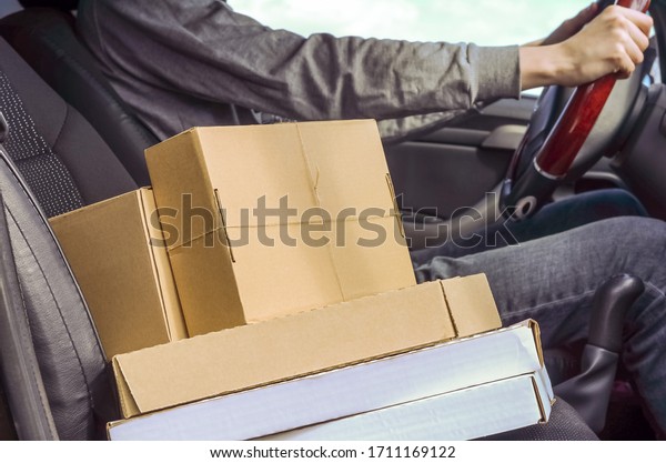 Courier with parcels in the car. Delivery of\
parcels, goods, pizza.