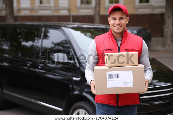 Courier with\
parcels near delivery van\
outdoors