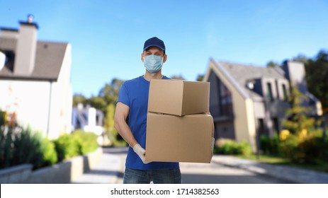 Courier In Protective Mask And Gloves With Boxes On Street. Delivery Service During Coronavirus Quarantine