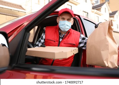 Courier In Protective Mask And Gloves With Orders Getting Out Of Car Outdoors. Food Delivery Service During Coronavirus Quarantine